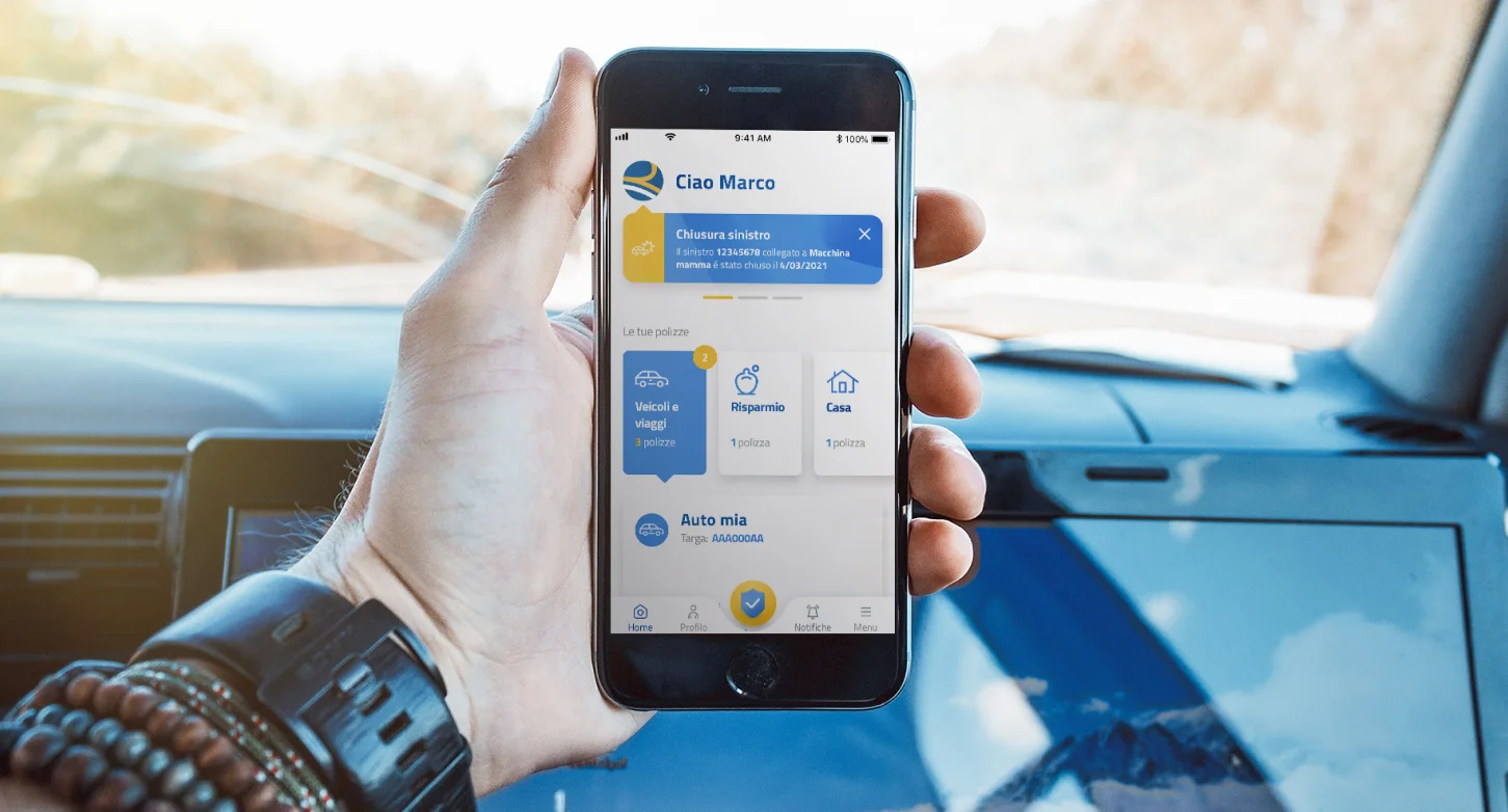 Hand holding a phone with the Reale Mutua app open